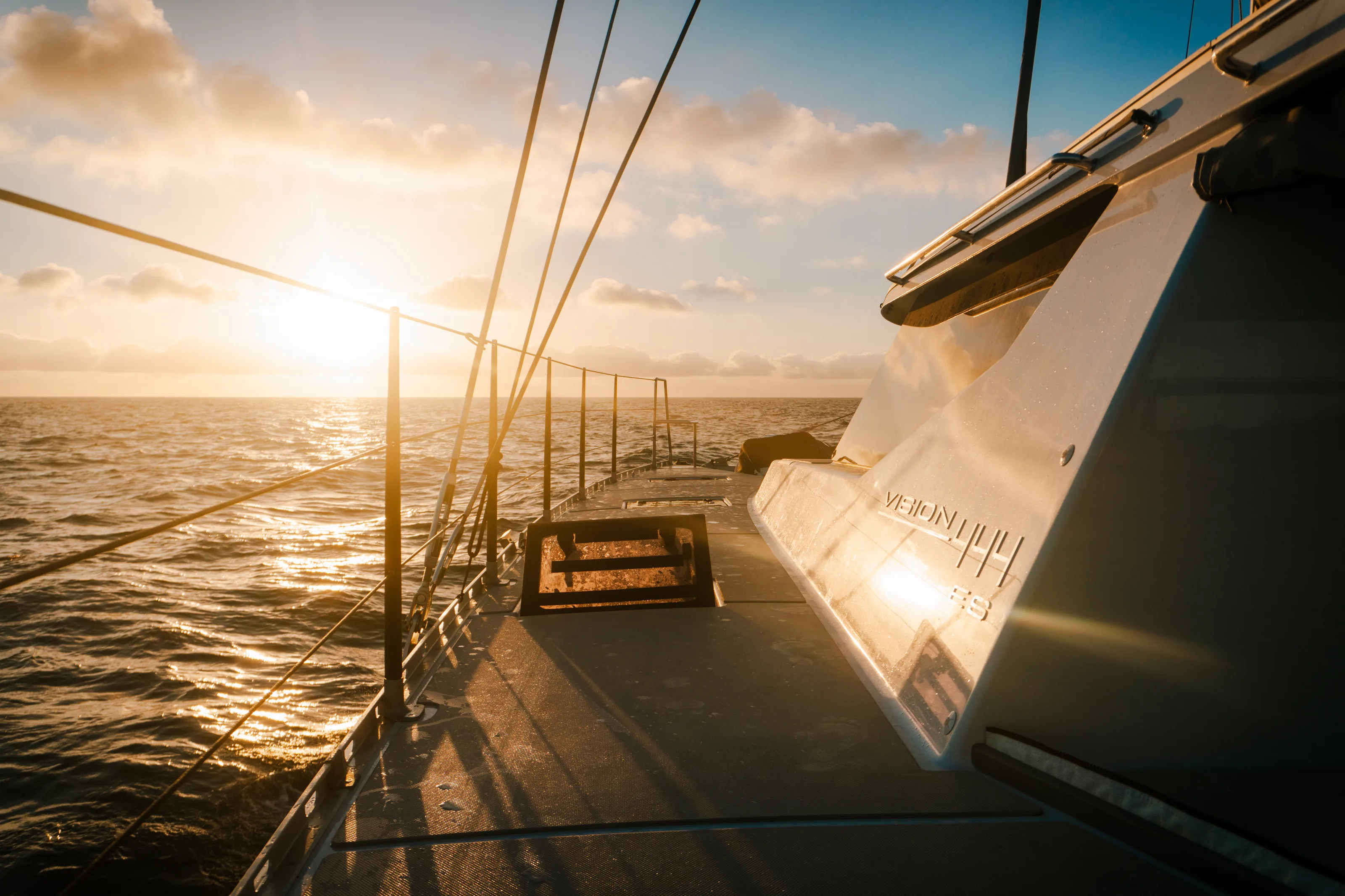 The side deck of a Vision catamaran at golden hour