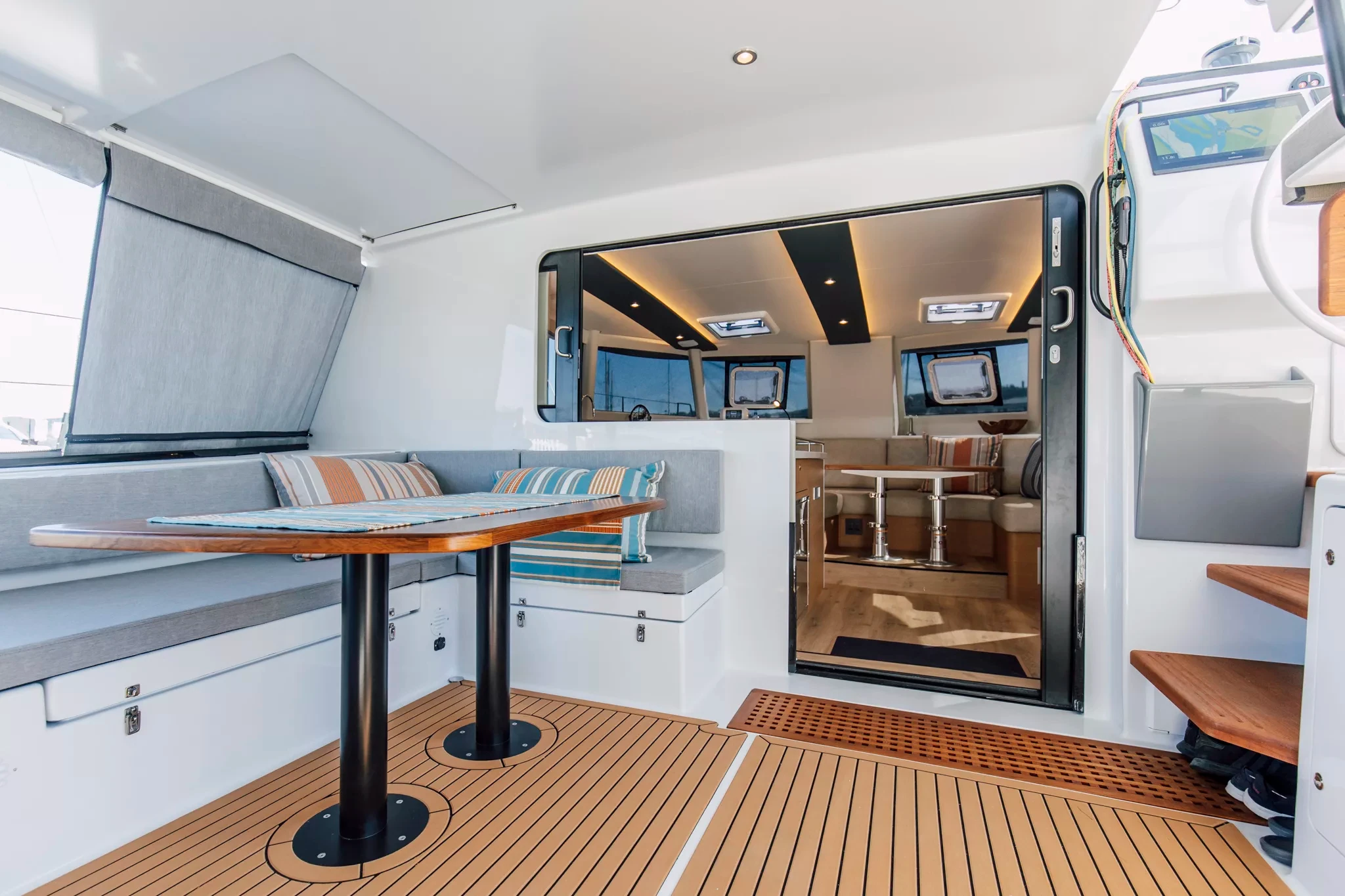 The aft deck of a Vision 444 ES, teak underfoot and the saloon doors open